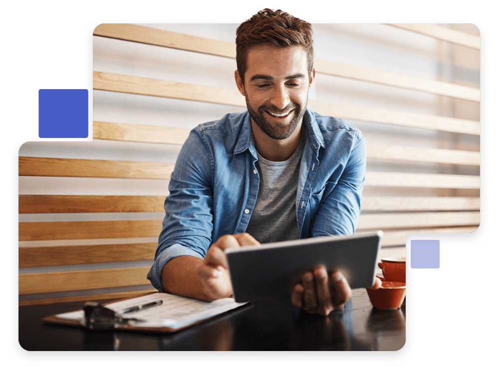 Homem sorrindo usando tablet em cafeteria