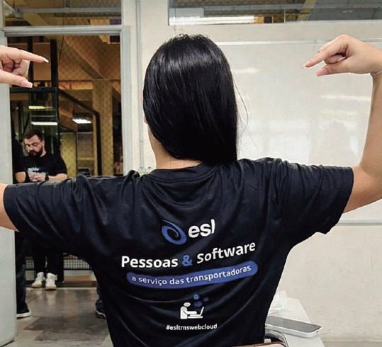 Pessoa apontando para camiseta ESL Pessoas e Software