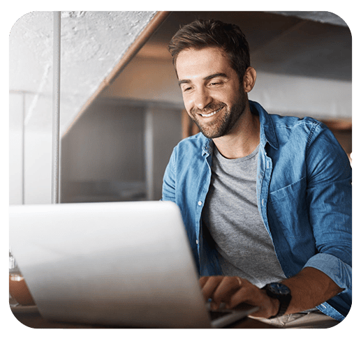 Homem sorrindo usando laptop em casa