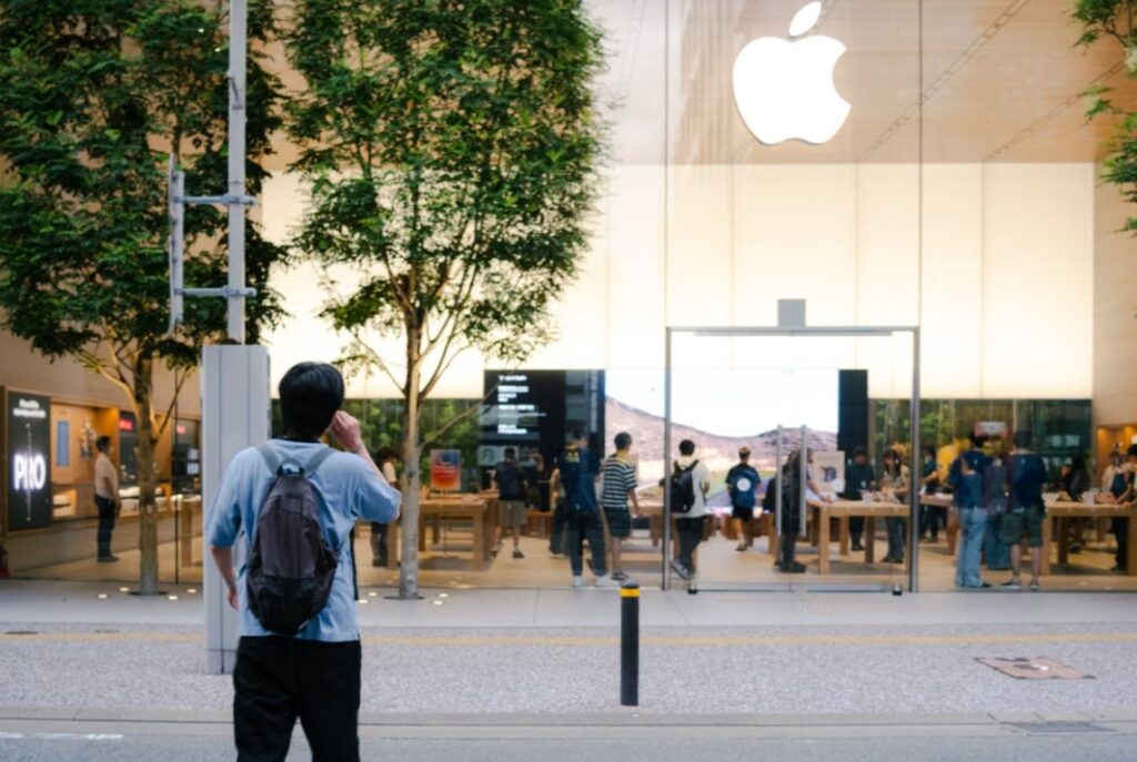 Fachada de loja Apple com clientes e logotipo iluminado