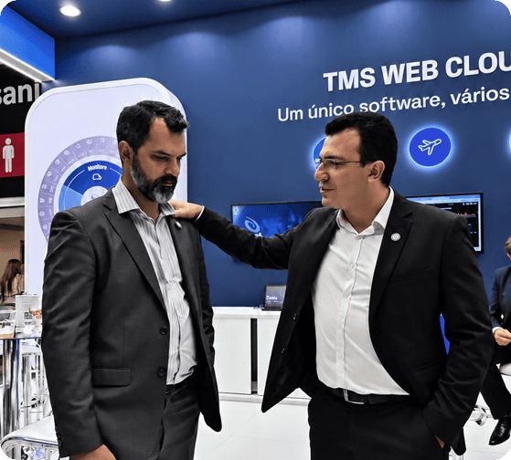 Dois executivos conversam em estande tecnológico azul