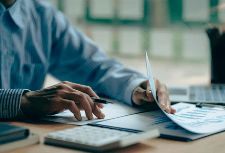 Profissional analisa gráficos financeiros em escritório