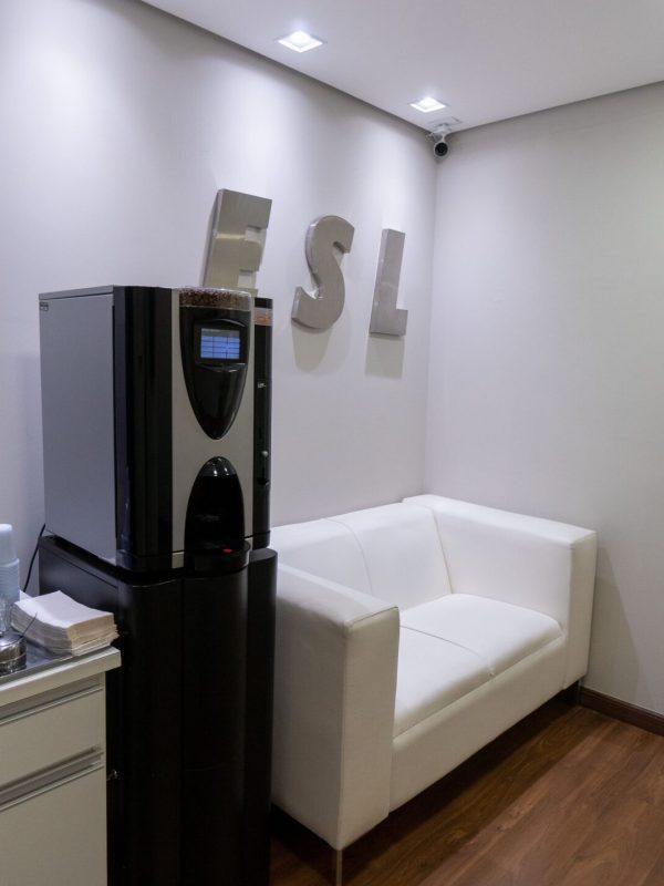 Sala de espera com sofá e máquina de café