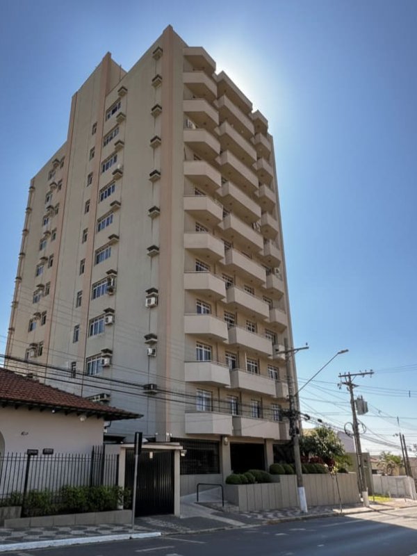 Prédio residencial alto com varandas visto da rua